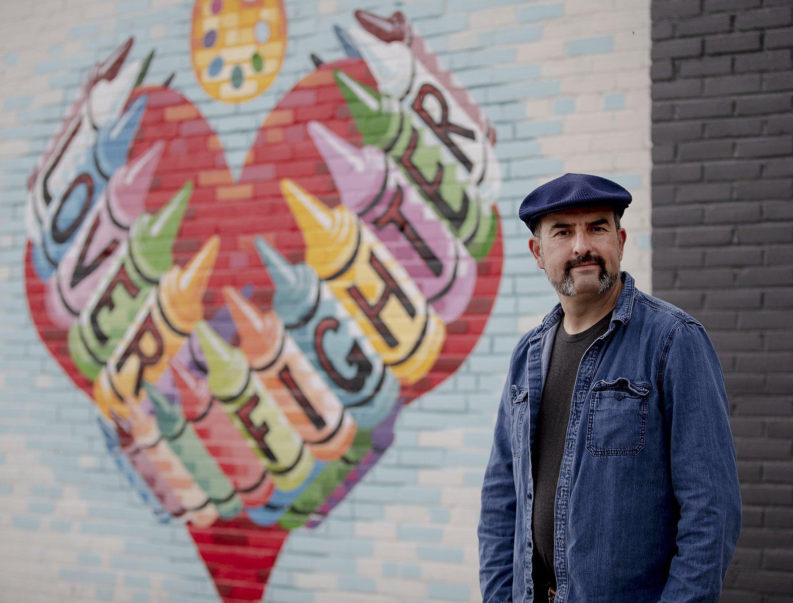 Artist Federico Archuleta, the man behind some of the most famous street art in Austin, poses for a photo Feb. 3 in front of his work "Lover, Fighter." [NICK WAGNER/AMERICAN-STATESMAN]