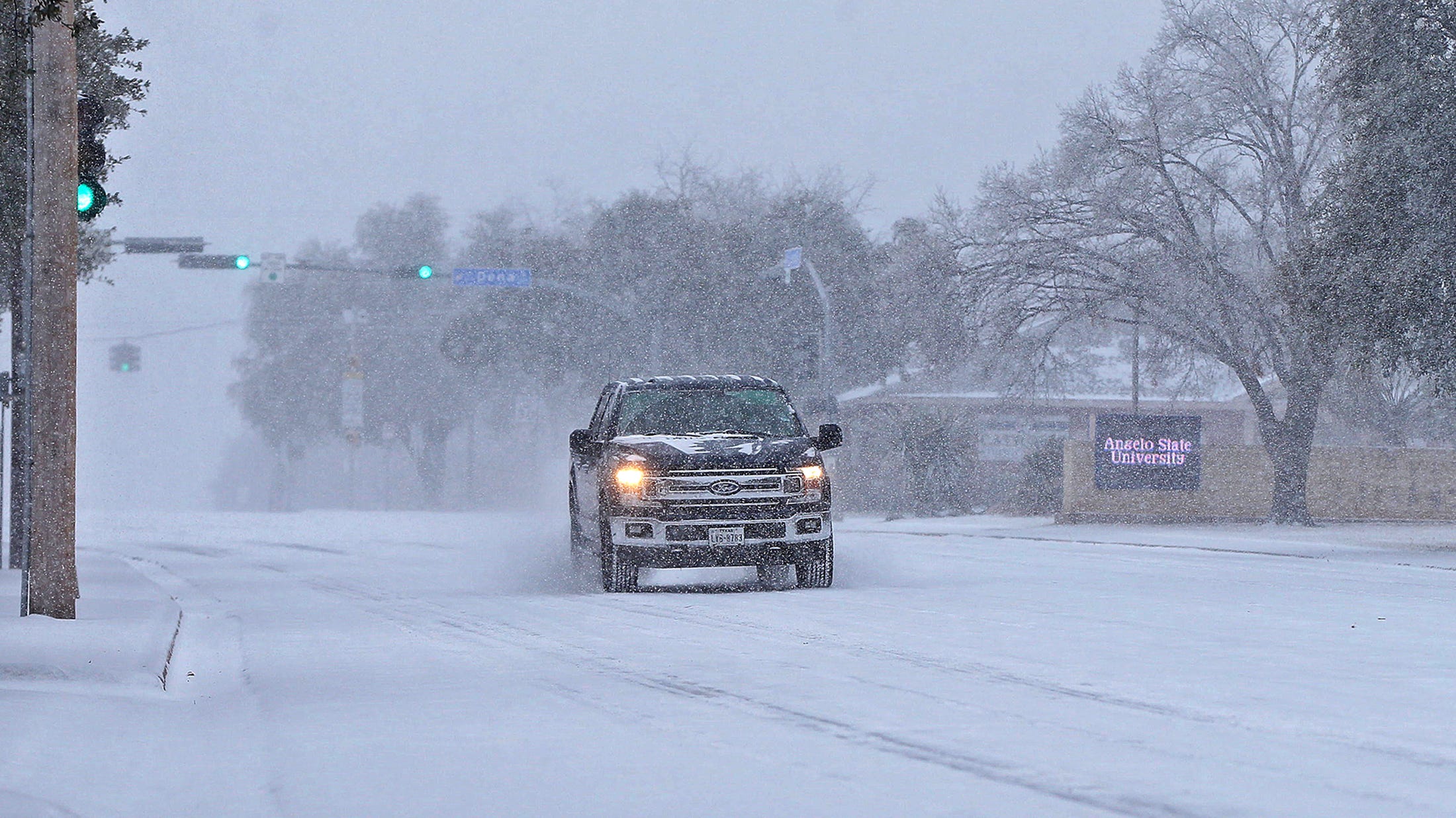 A vehicle drives through the snow near the Angelo State University campus on S. Johnson St. on Sunday, Feb. 14, 2021.