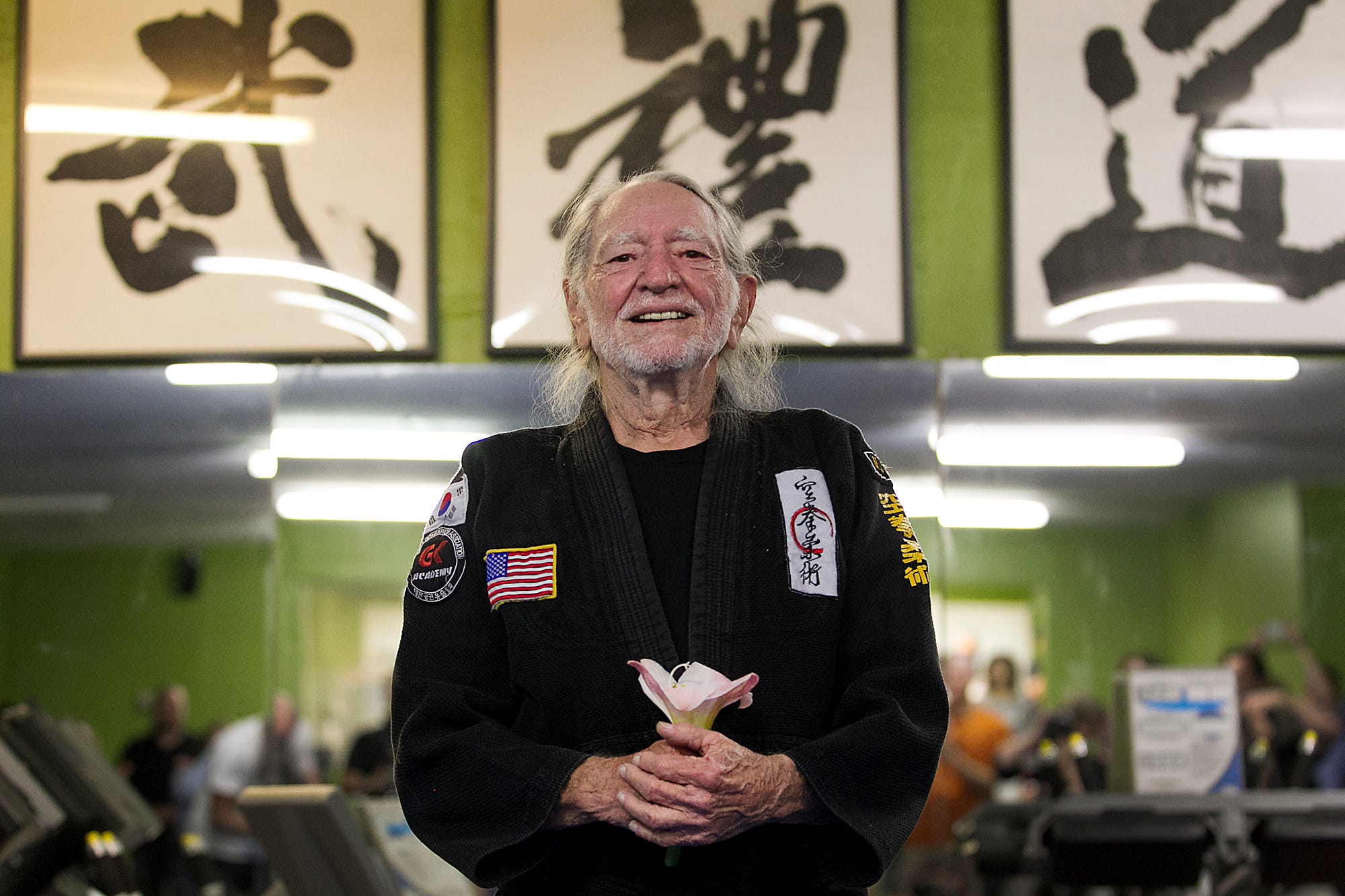 Austin music legend Willie Nelson celebrated his 81st birthday one day early by being presented with his fifth-degree black belt in Gong Kwon Yu Sul by Master Um of Master Martial Arts in Austin, TX. Nelson holds a flower given to him by Ava Golab, 6, as the crowd serenaded him a chorus of Happy Birthday. Nelson has been studying for twenty years and finally reached the lofty status of Master, as he was presented in a ceremony on April 28, 2014.