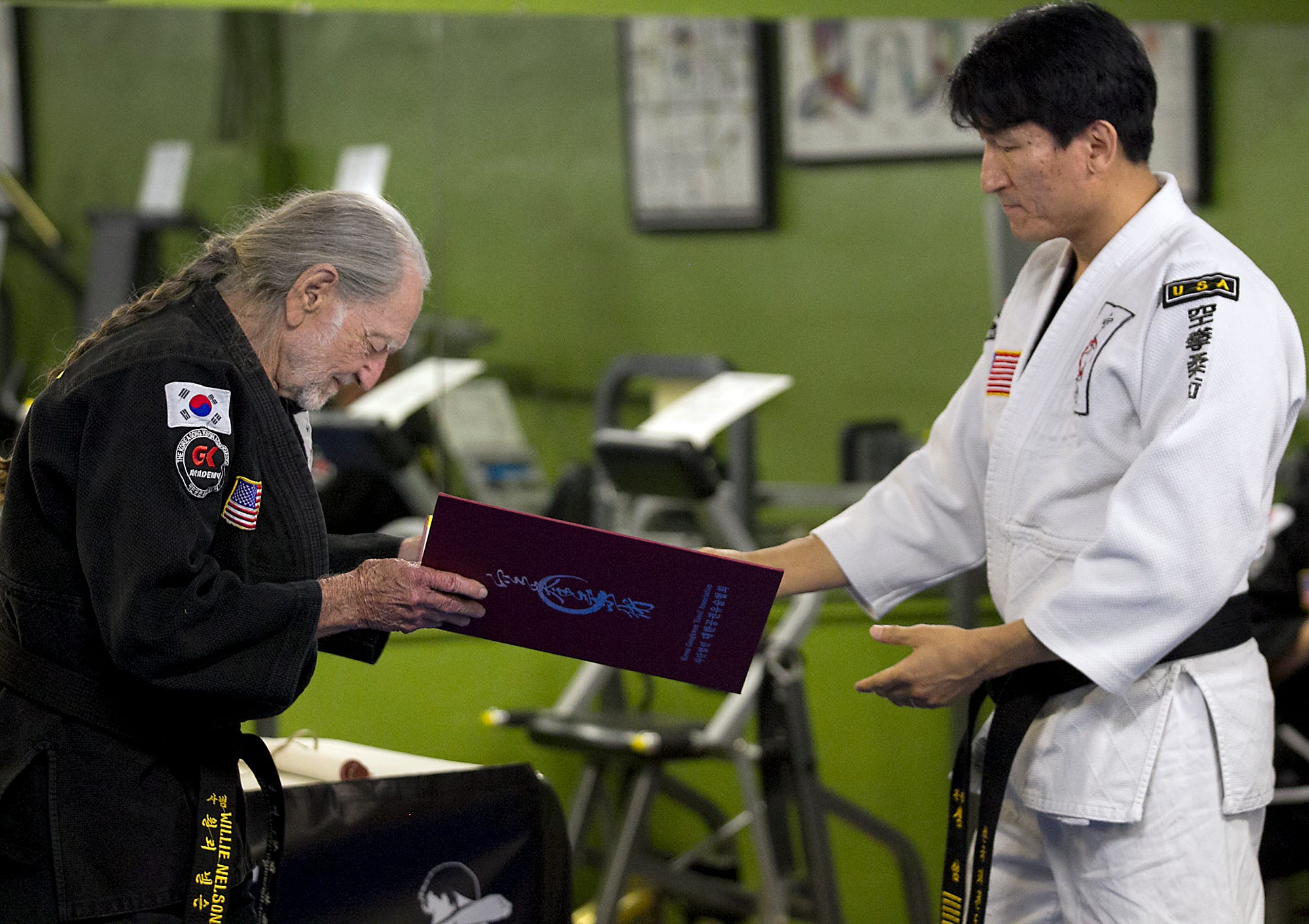 Austin music legend Willie Nelson celebrated his 81st birthday one day early by being presented with his fifth-degree black belt in Gong Kwon Yu Sul by Master Um of Master Martial Arts in Austin, TX. Sam Um presents Nelson with a certificate and scroll signifying his status of Master. Nelson has been studying for twenty years and finally reached the lofty status of Master, as he was presented in a ceremony on April 28, 2014.
