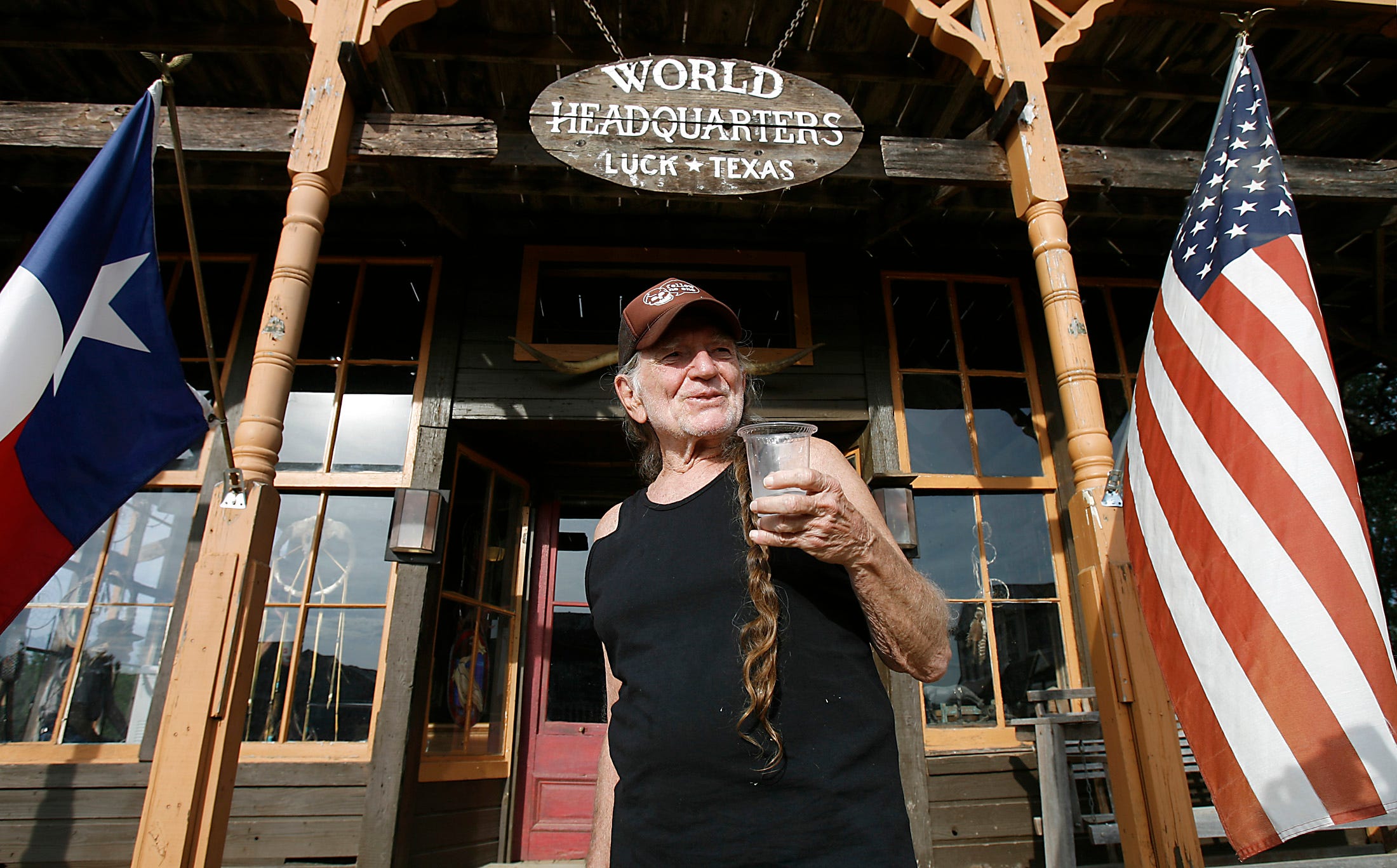 Willie Nelson smiles and poses with a cup of cold water from the Water from Air water cooler that he and Runtex owner, Paul Carrozo are teaming up to market during a visit to Nelson's World Headquarters on Friday, September 12, 2008.
